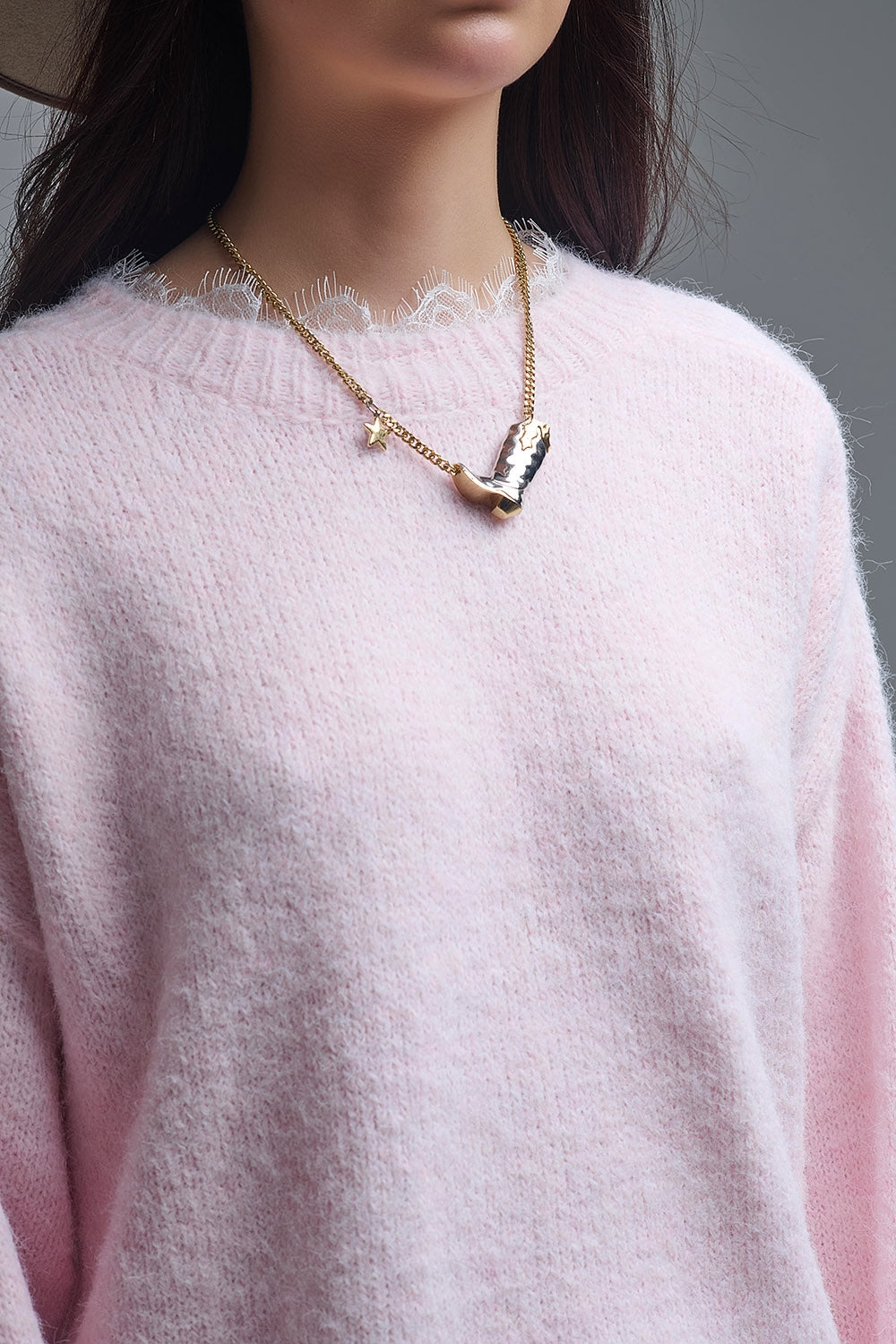 Detalle del cuello de encaje de un jersey rosa de punto suave