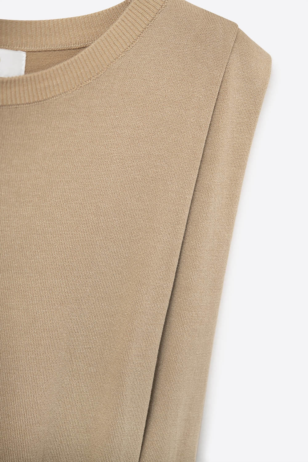 Detalle del tejido de punto fino de viscosa y de la hombrera de un top sin mangas color camel.