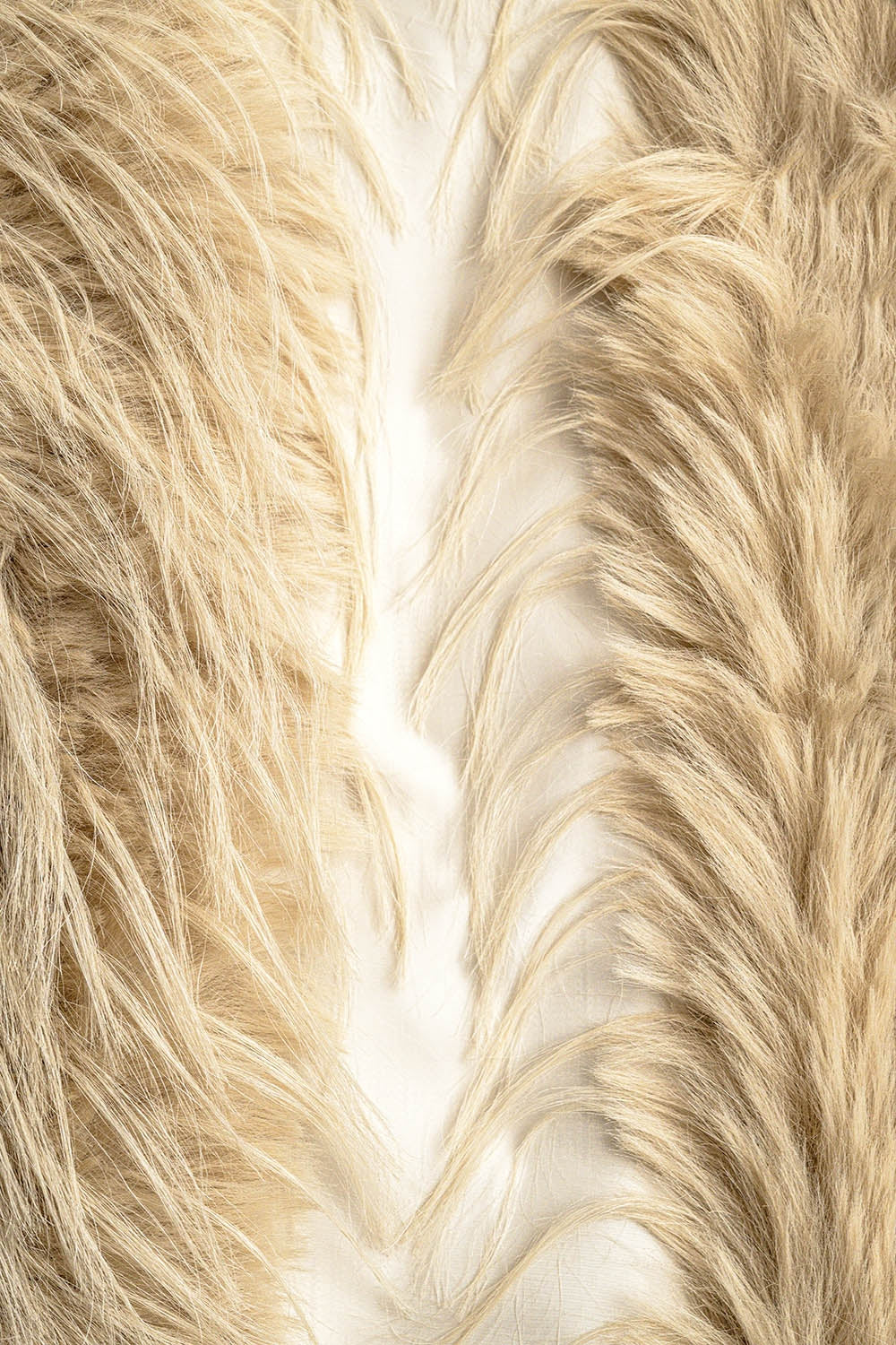 Primer plano de la textura de un tejido de pelo largo y "shaggy" en color beige.