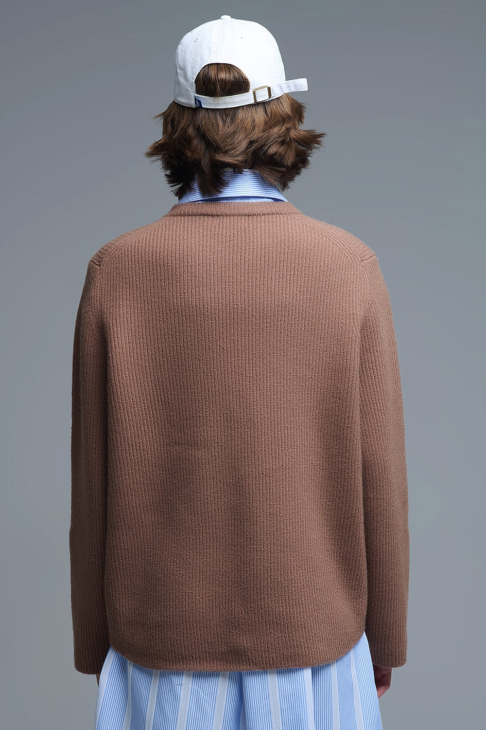 Vista trasera de un jersey de punto acanalado en color camel con corte oversize.