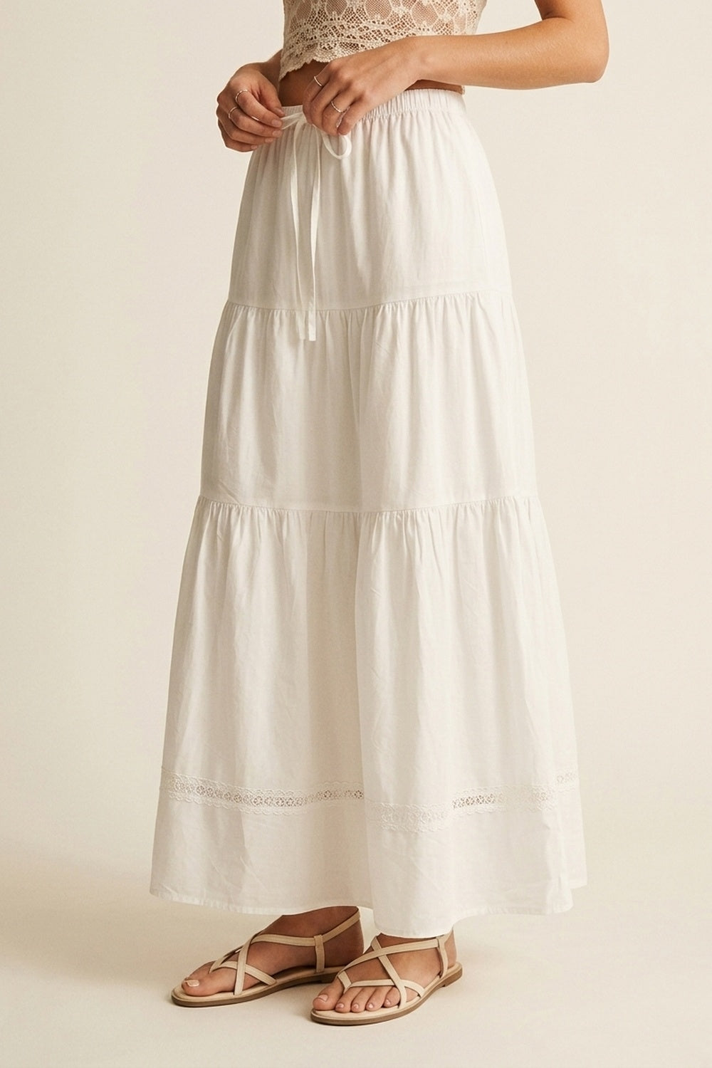 Vista frontal de falda larga blanca de algodón con cintura elástica y diseño escalonado.