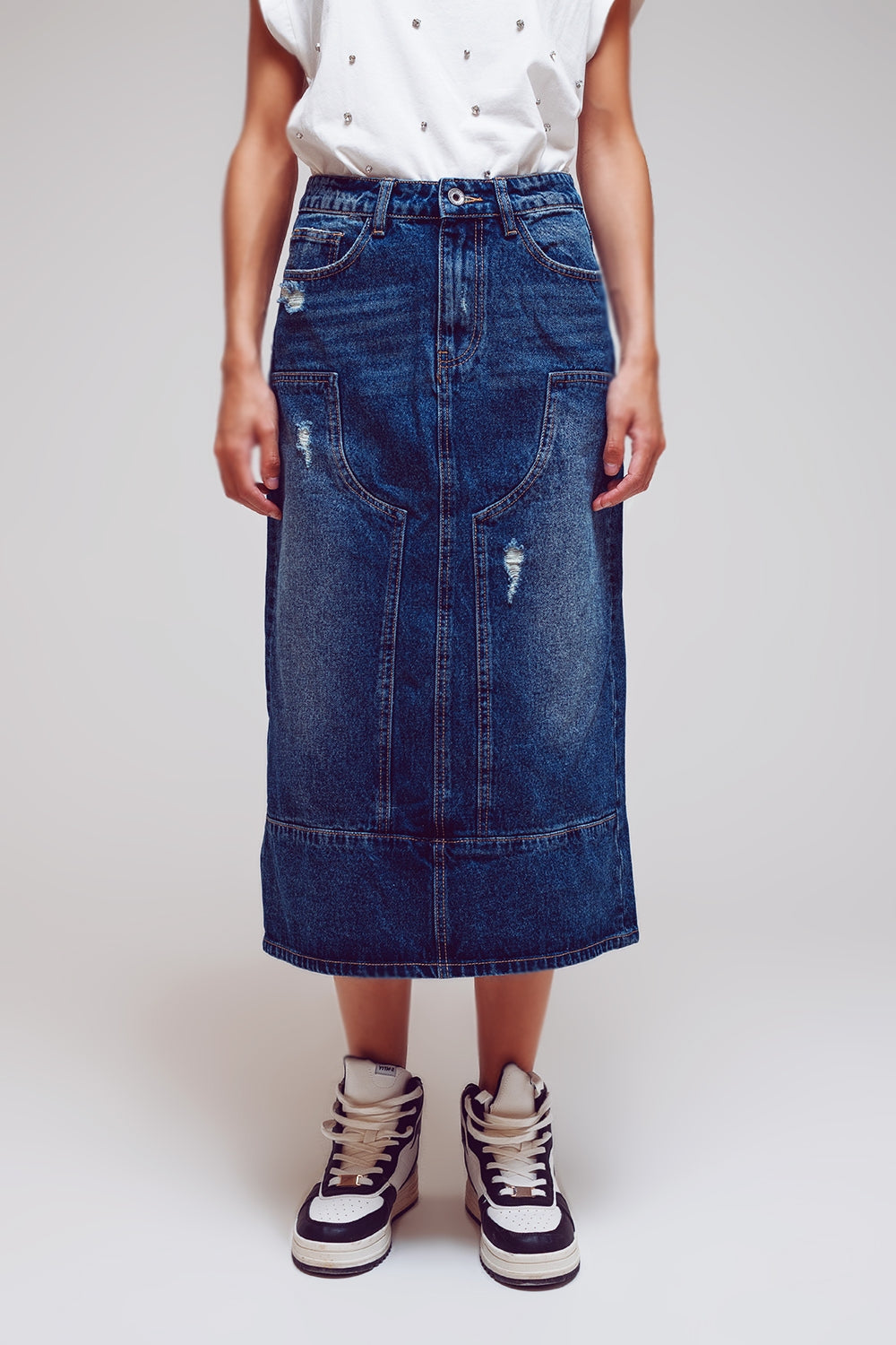 Detalle de la cintura y los paneles de una falda vaquera larga de denim rígido.