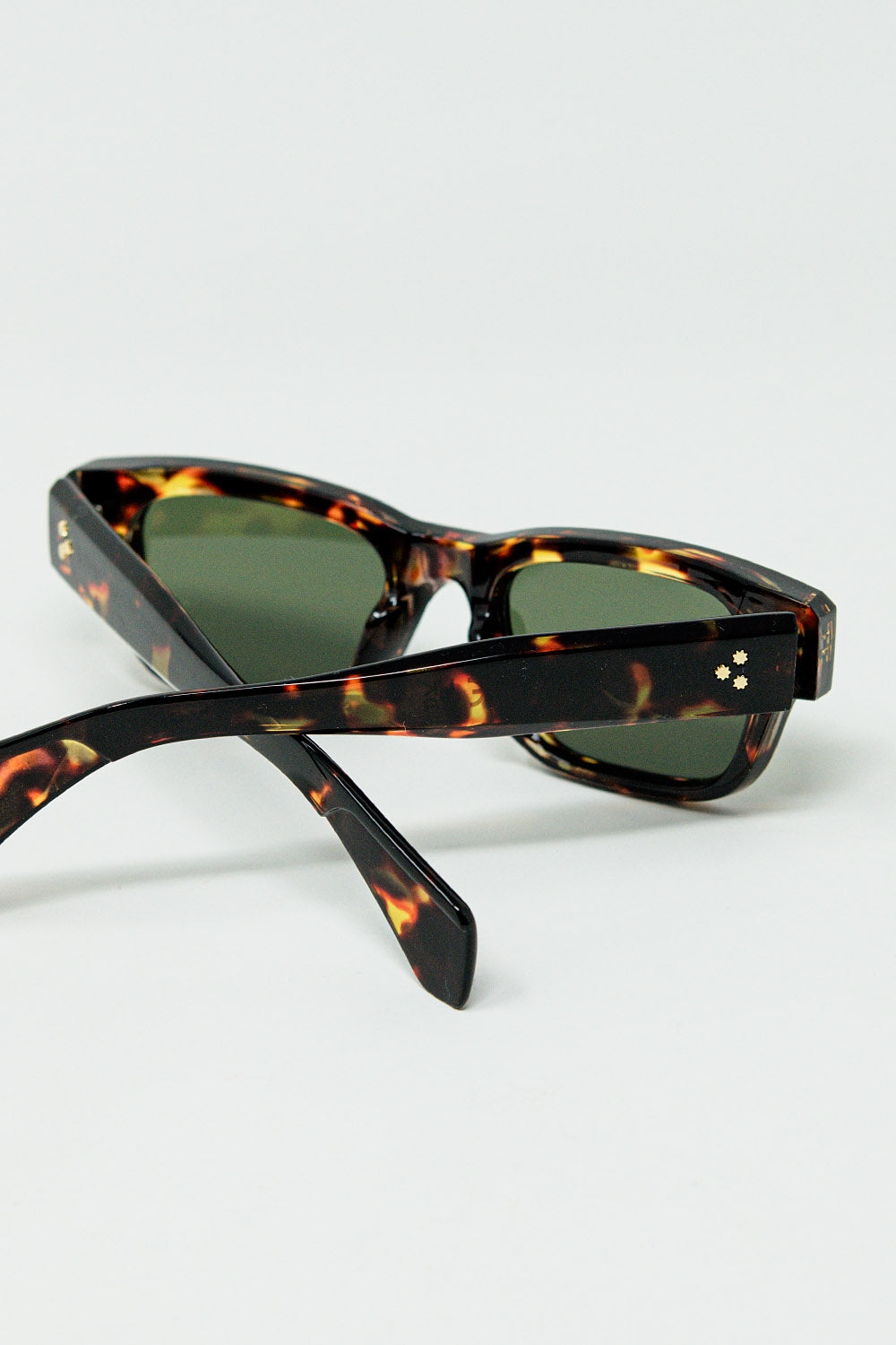 Gafas de sol color ámbar con lentes ovaladas de color verde oscuro