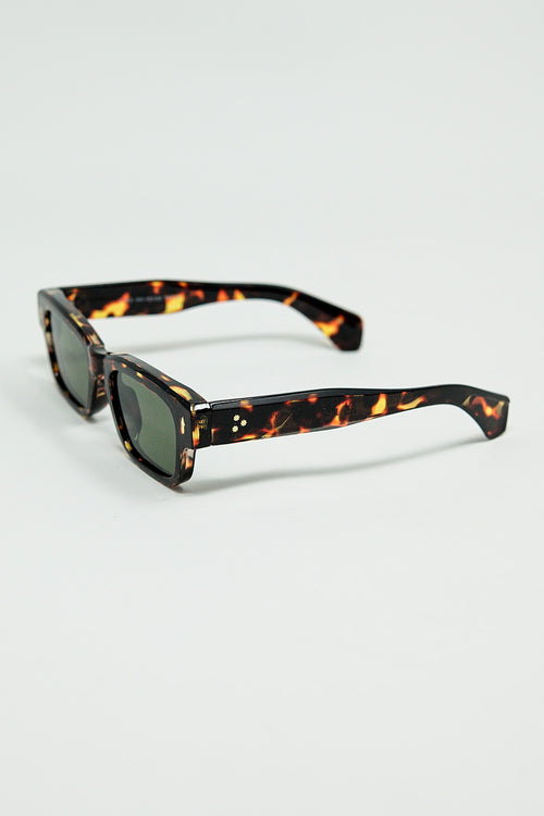 Gafas de sol color ámbar con lentes ovaladas de color verde oscuro