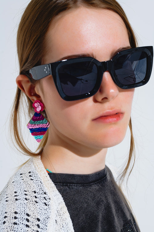 Modelo con gafas de sol cuadradas con cristales oscuros en negro