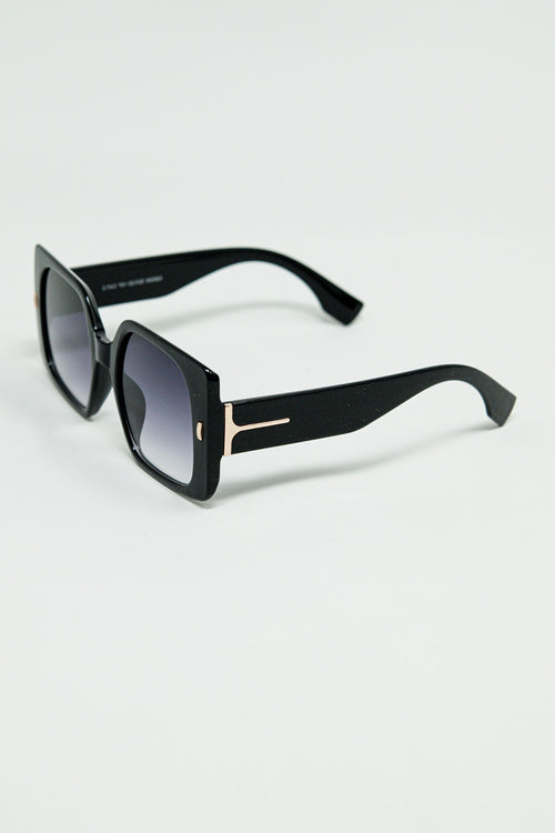 Gafas de sol cuadradas negras con detalle dorado en el lateral