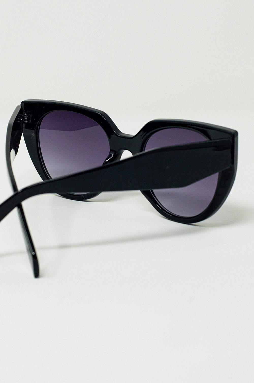 Gafas de sol estilo ojo de gato extragrandes con ribete ancho en negro.