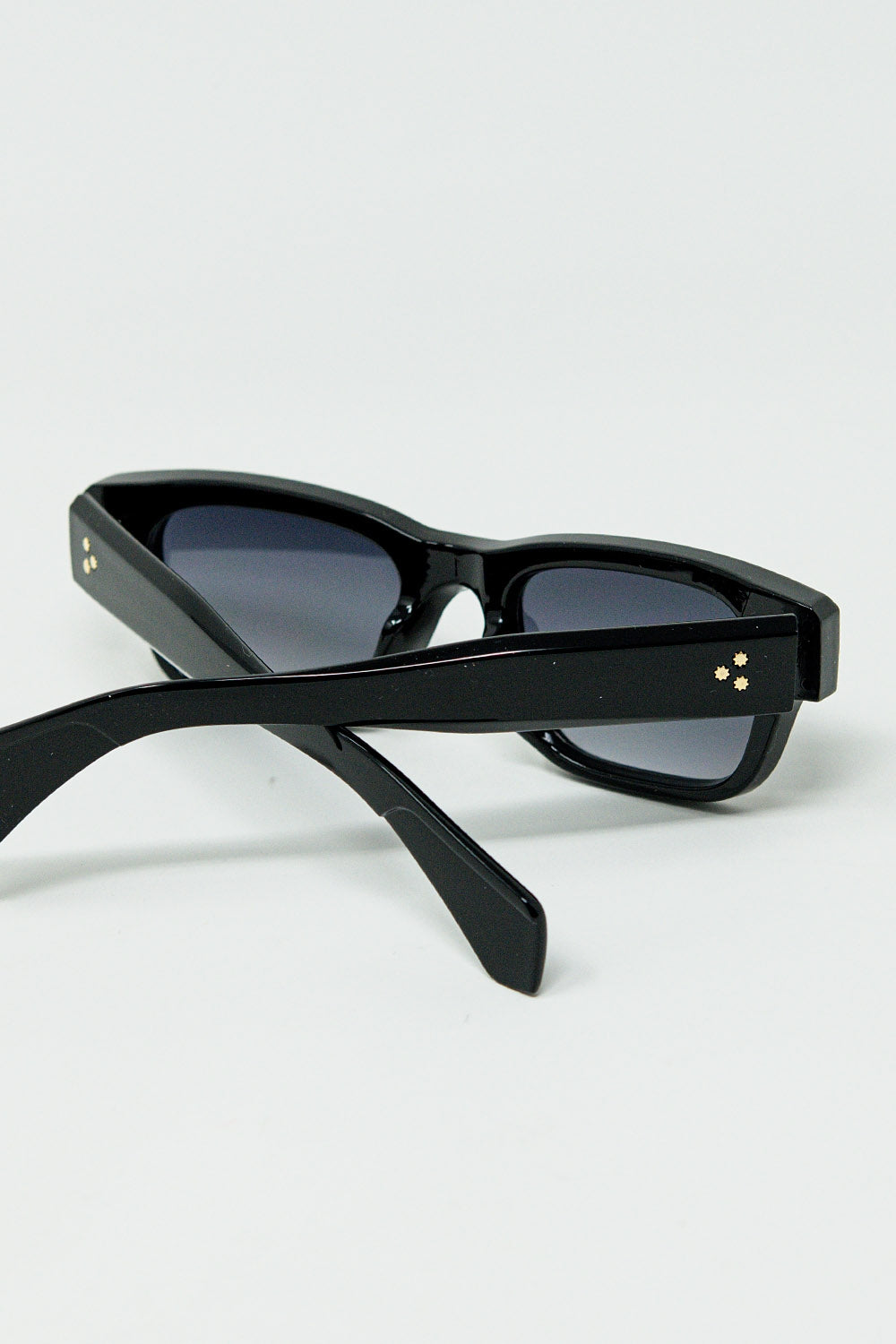 Gafas de sol negras con montura ovalada con detalle dorado
