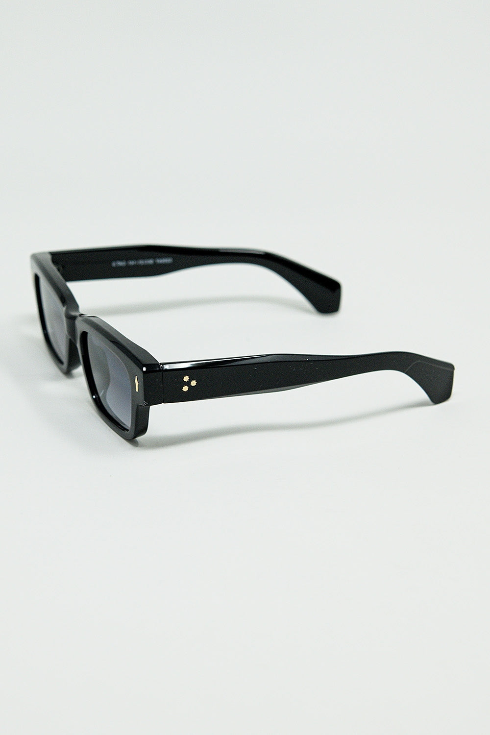 Gafas de sol negras con montura ovalada con detalle dorado