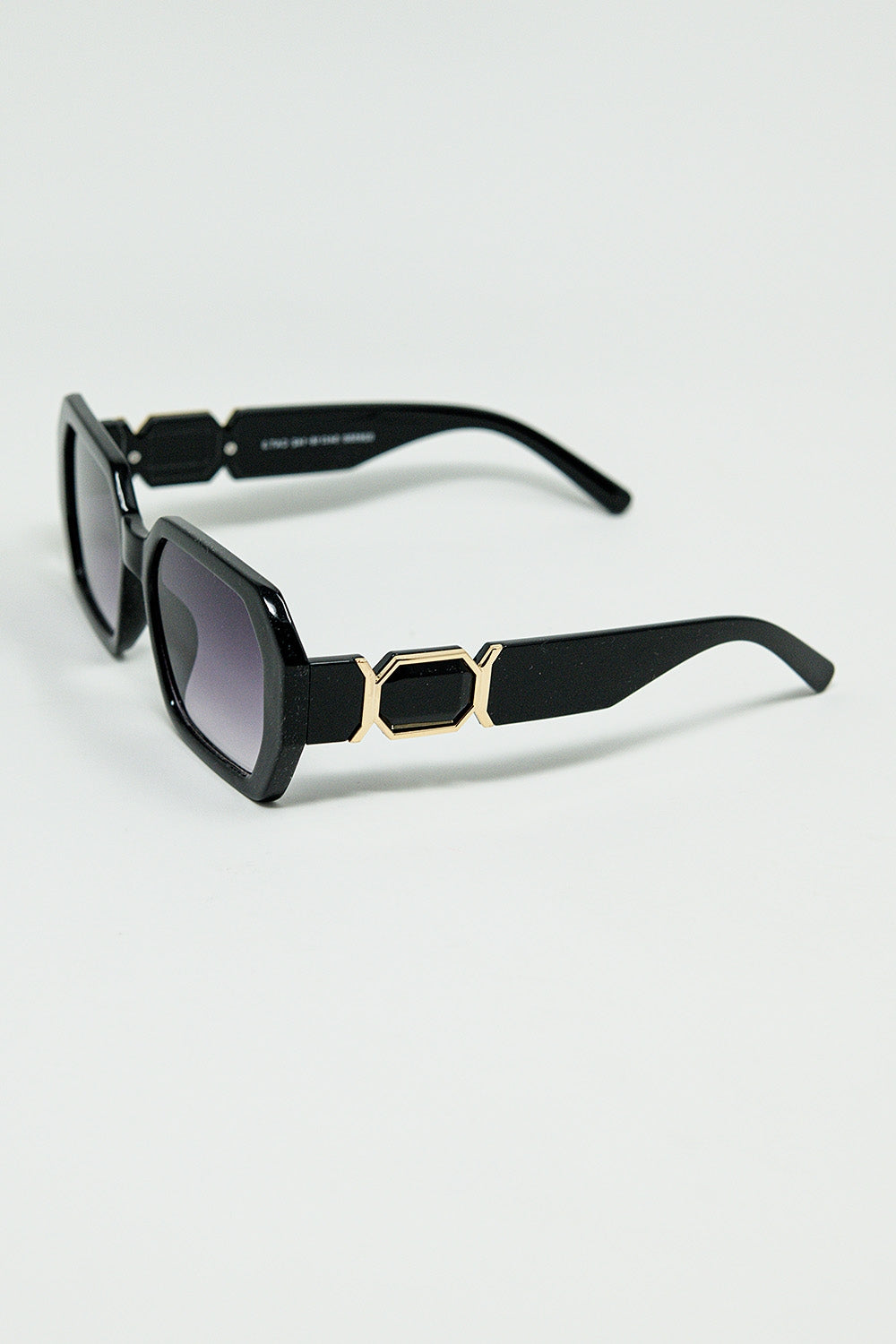 Gafas de sol negras en forma de diamante y detalle dorado