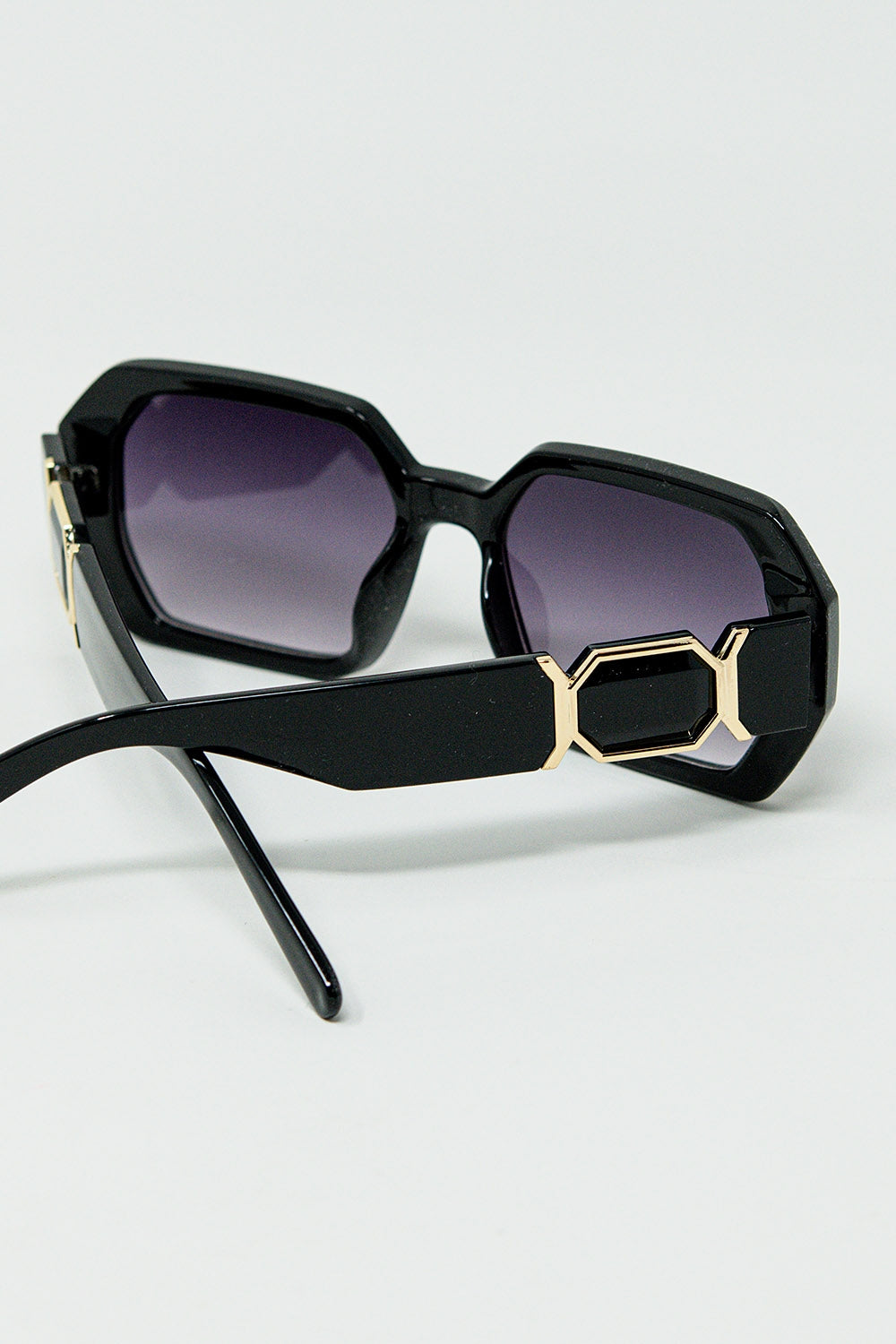 Gafas de sol negras en forma de diamante y detalle dorado