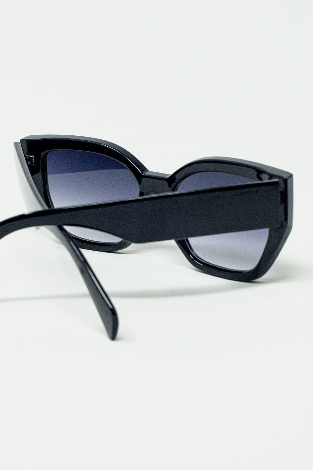 Gafas de sol negras gruesas y geométricas con lentes degradadas
