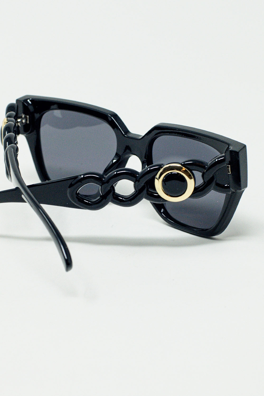 Vista lateral de gafas de sol negras con diseño elegante y moderno.