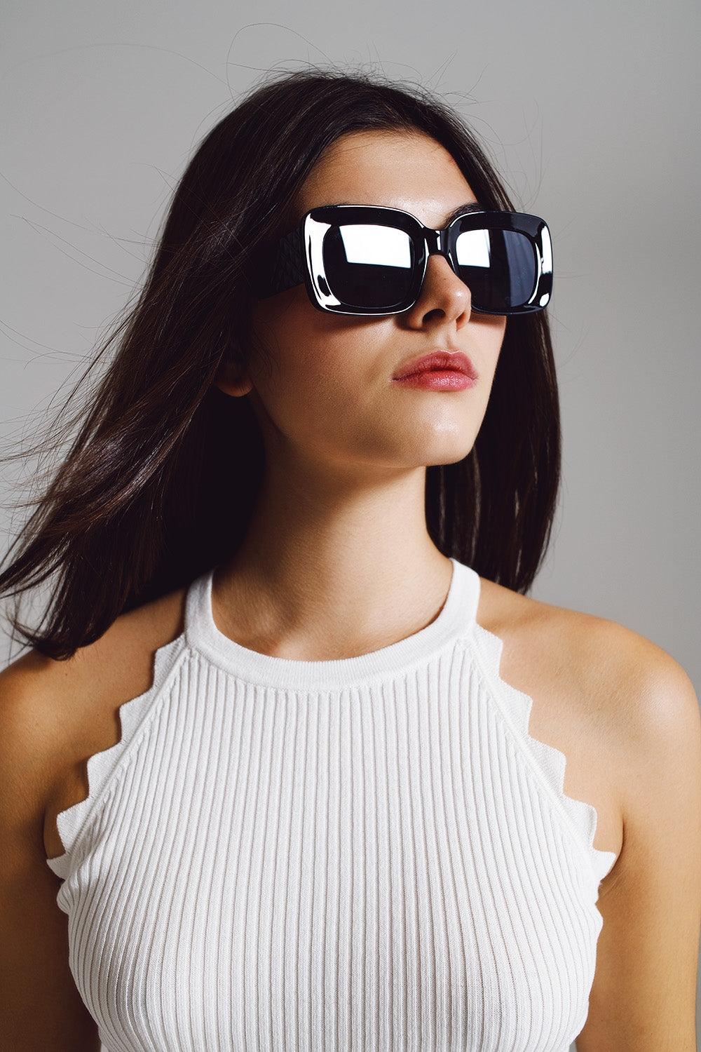 Modelo con gafas de sol ovaladas extragrandes con detalle lateral en negro
