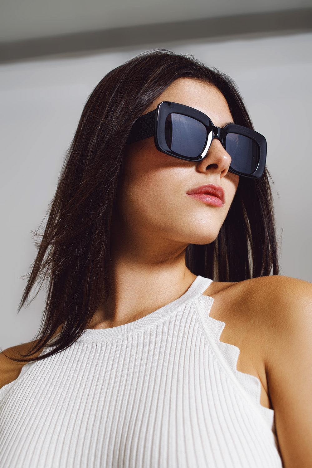 Modelo con gafas de sol ovaladas extragrandes con detalle lateral en negro