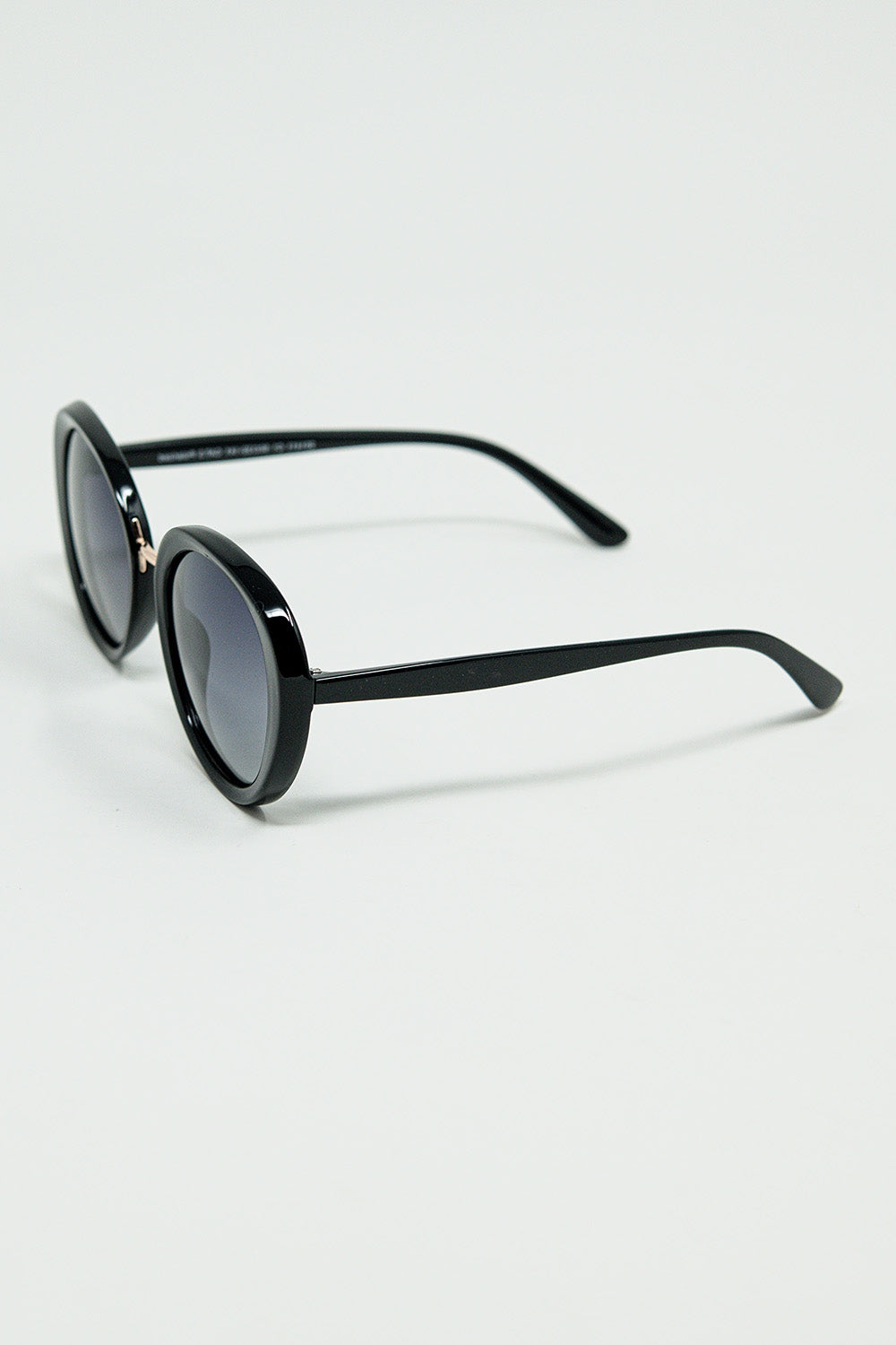 Gafas de sol ovaladas negras con detalle metálico dorado