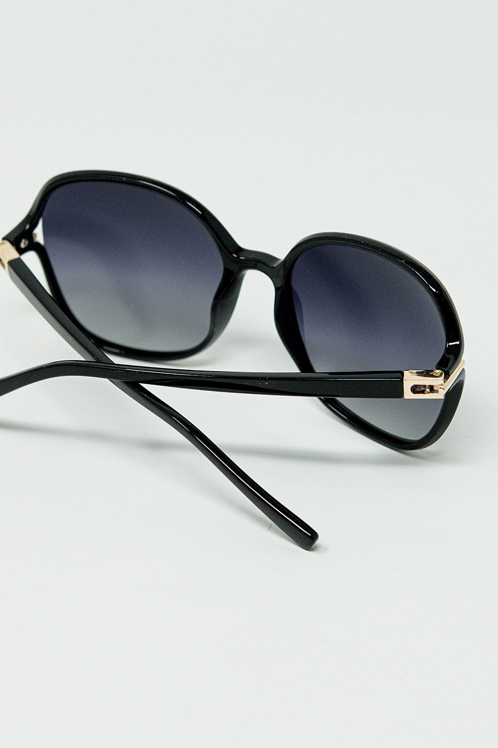 Gafas de sol redondas en negro con detalle metálico dorado