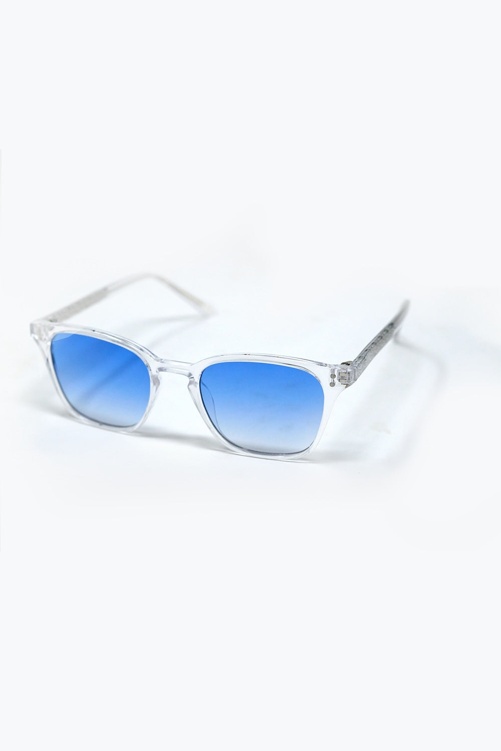 Gafas de sol cuadradas con montura transparente y lentes azules degradadas vista lateral.