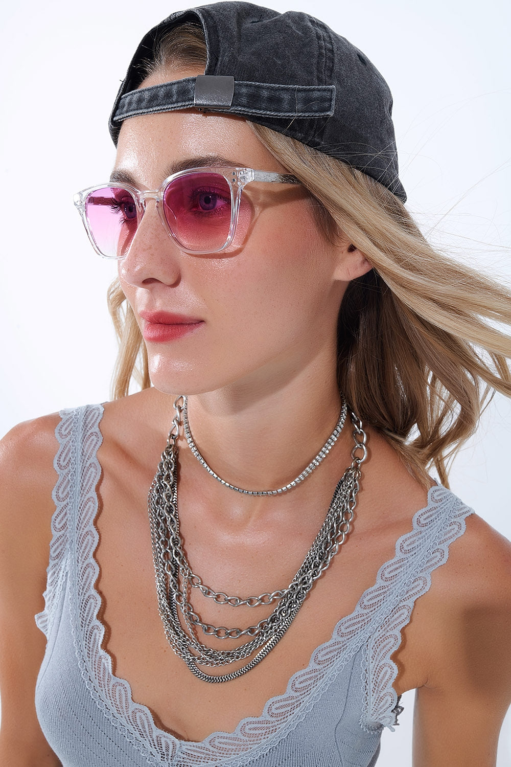 Mujer con gafas de sol cuadradas transparentes con lentes rosa degradadas.