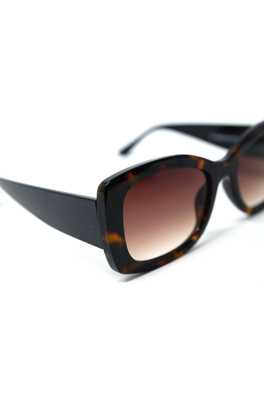 Gafas de sol ovaladas oversize con montura carey y cristales marrones degradados vista en ángulo.