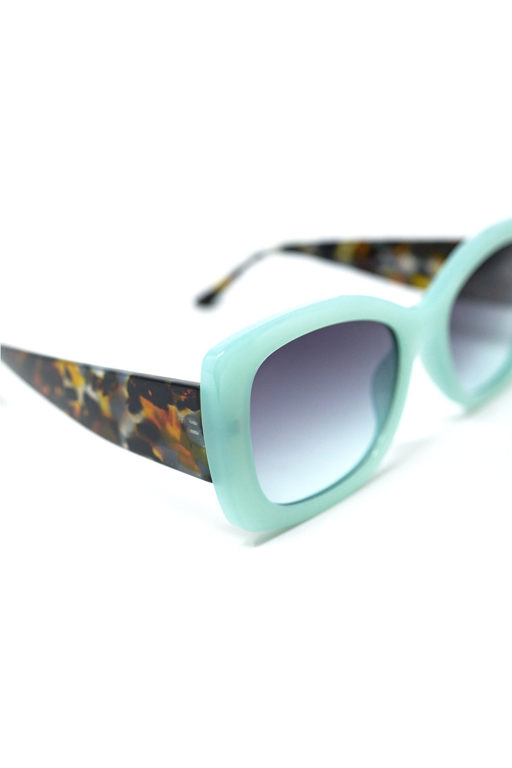 Gafas de sol ovaladas verde menta con patillas carey y cristales degradados grises vista en ángulo.
