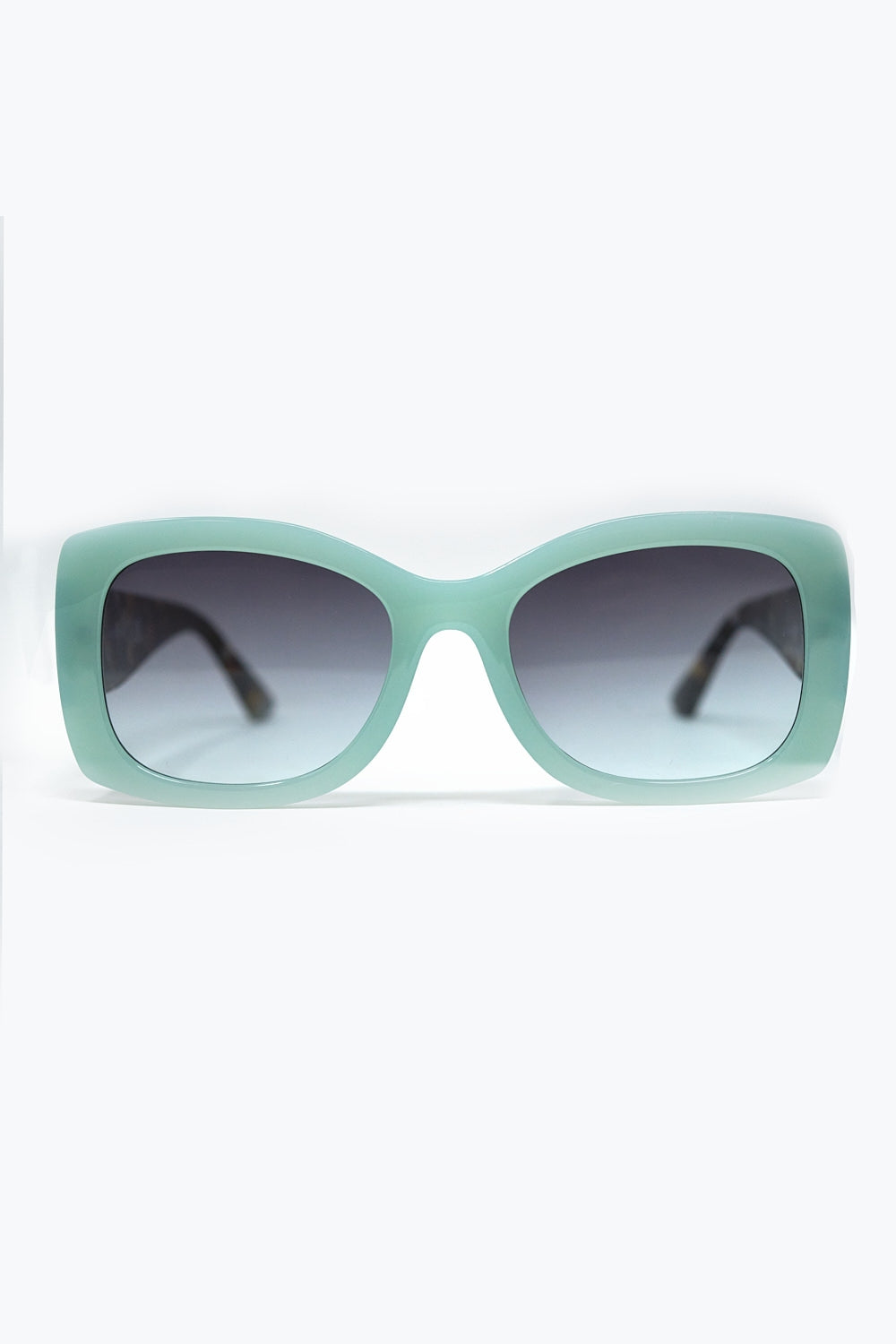 Gafas de sol ovaladas verde menta con patillas carey y cristales degradados grises vista frontal.
