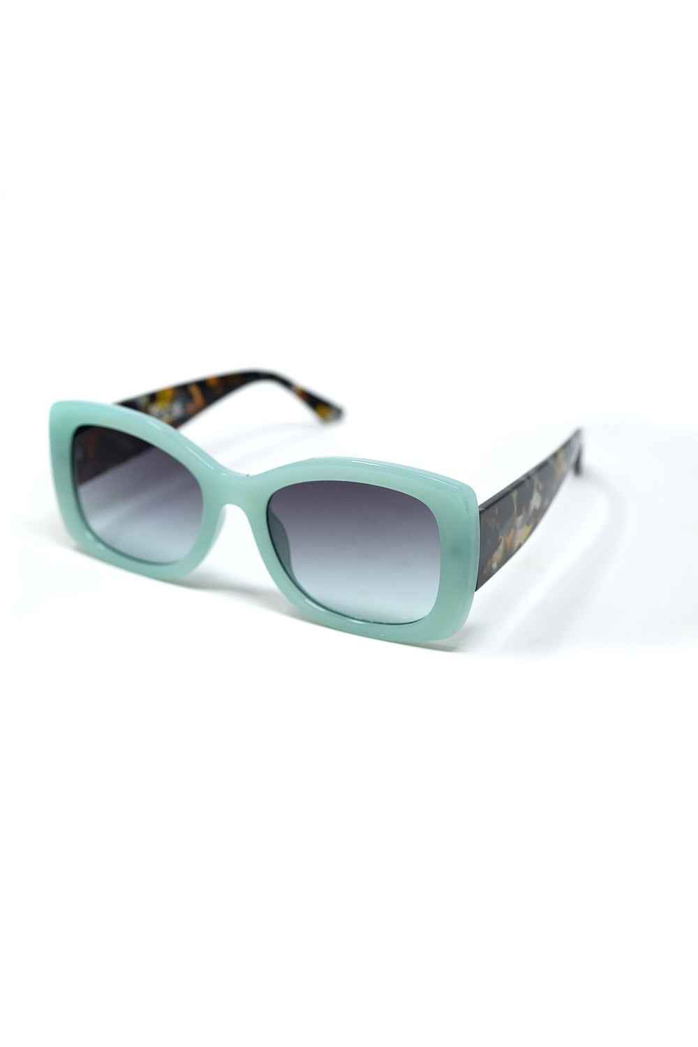 Gafas de sol ovaladas verde menta con patillas carey y cristales degradados grises vista lateral.