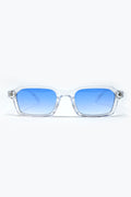 Gafas de sol rectangulares con montura transparente y lentes azules degradadas vista frontal.