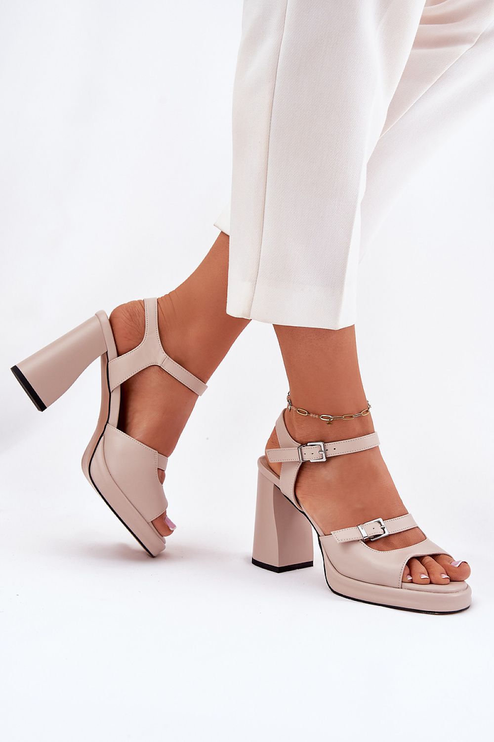 Mujer luciendo sandalias nude con pantalón claro – detalle de estilo