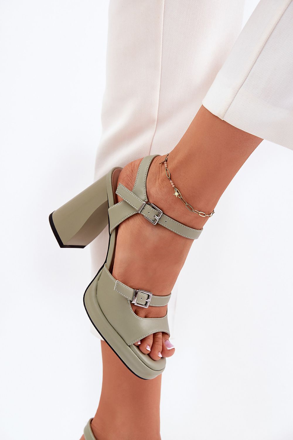 Mujer con sandalias de tacón verde salvia – detalle en el tobillo