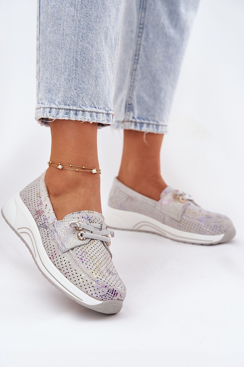 Zapatillas grises de ante con plataforma y detalles brillantes, vista lateral sobre fondo blanco.