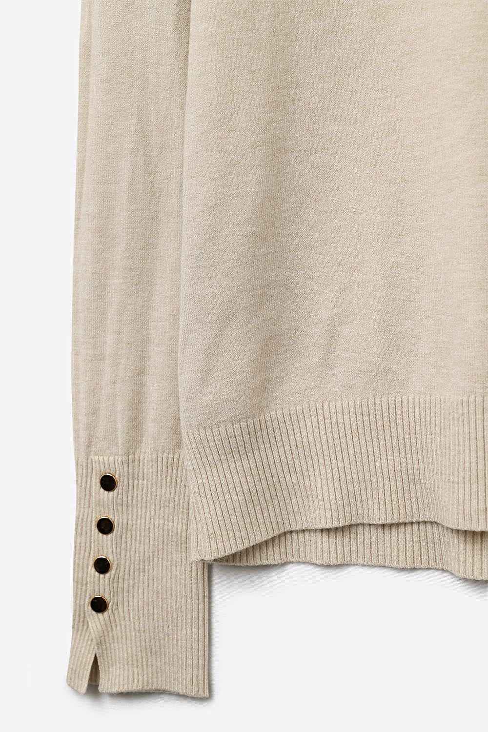 jersey beige de cuello alto con botones dorados en el puño 