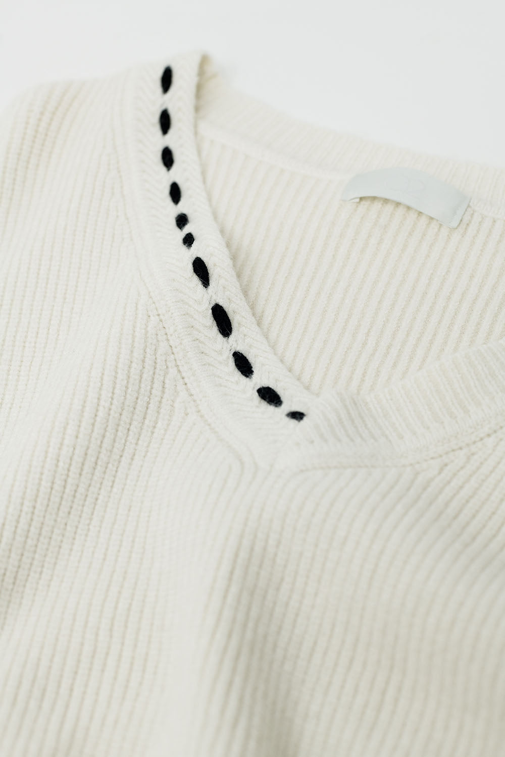 Jersey con cuello de pico y detalle bordado en negro