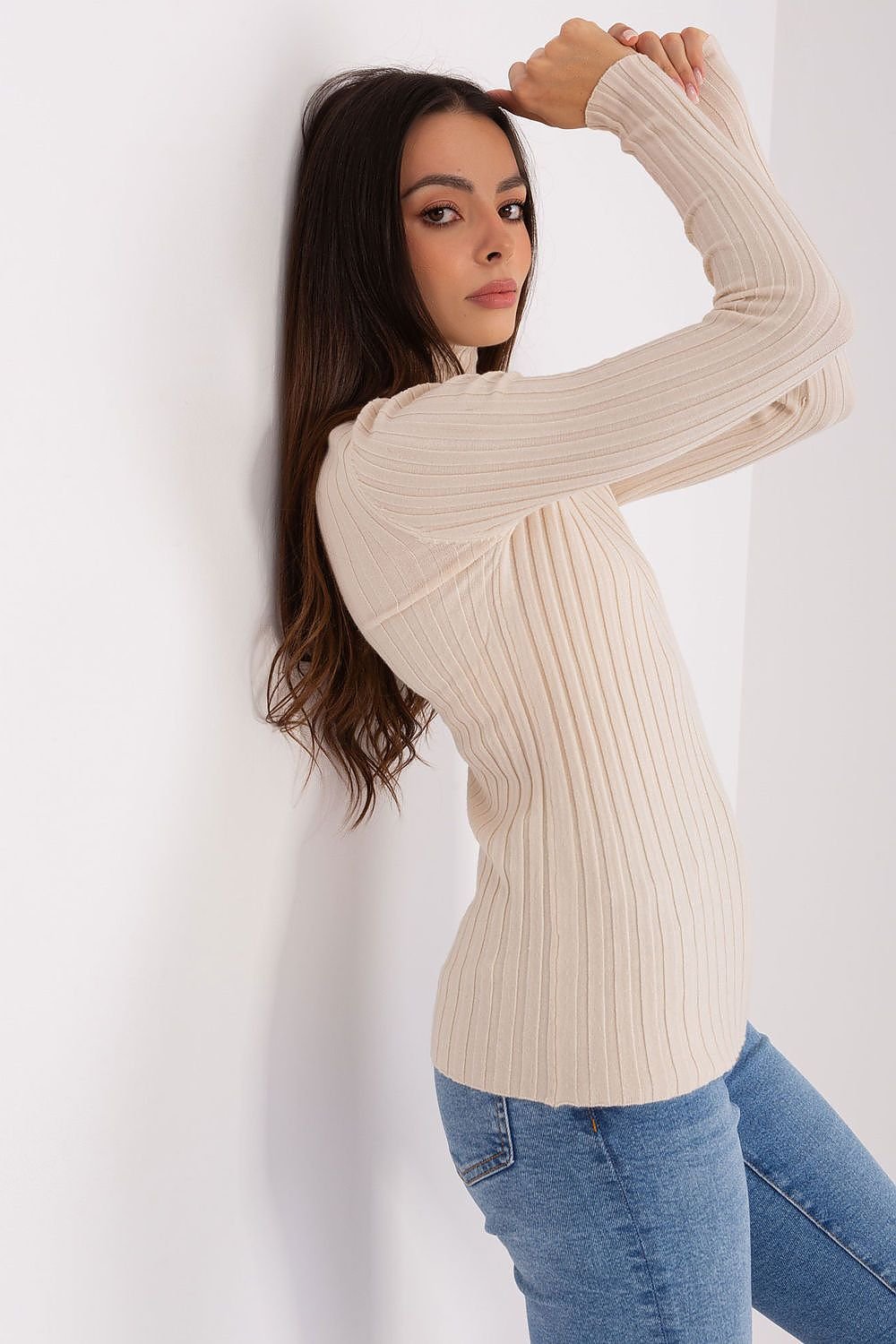 Detalle del tejido acanalado del jersey beige de cuello alto, fabricado bajo prácticas sostenibles y éticas.