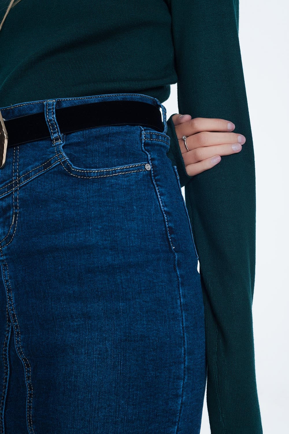 jersey de mujer en color verde oscuro, tejido de canalé con detalle de volante en el cuello y silueta ajustada.