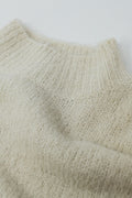 Jersey esponjoso beige con cuello alto y mangas globo