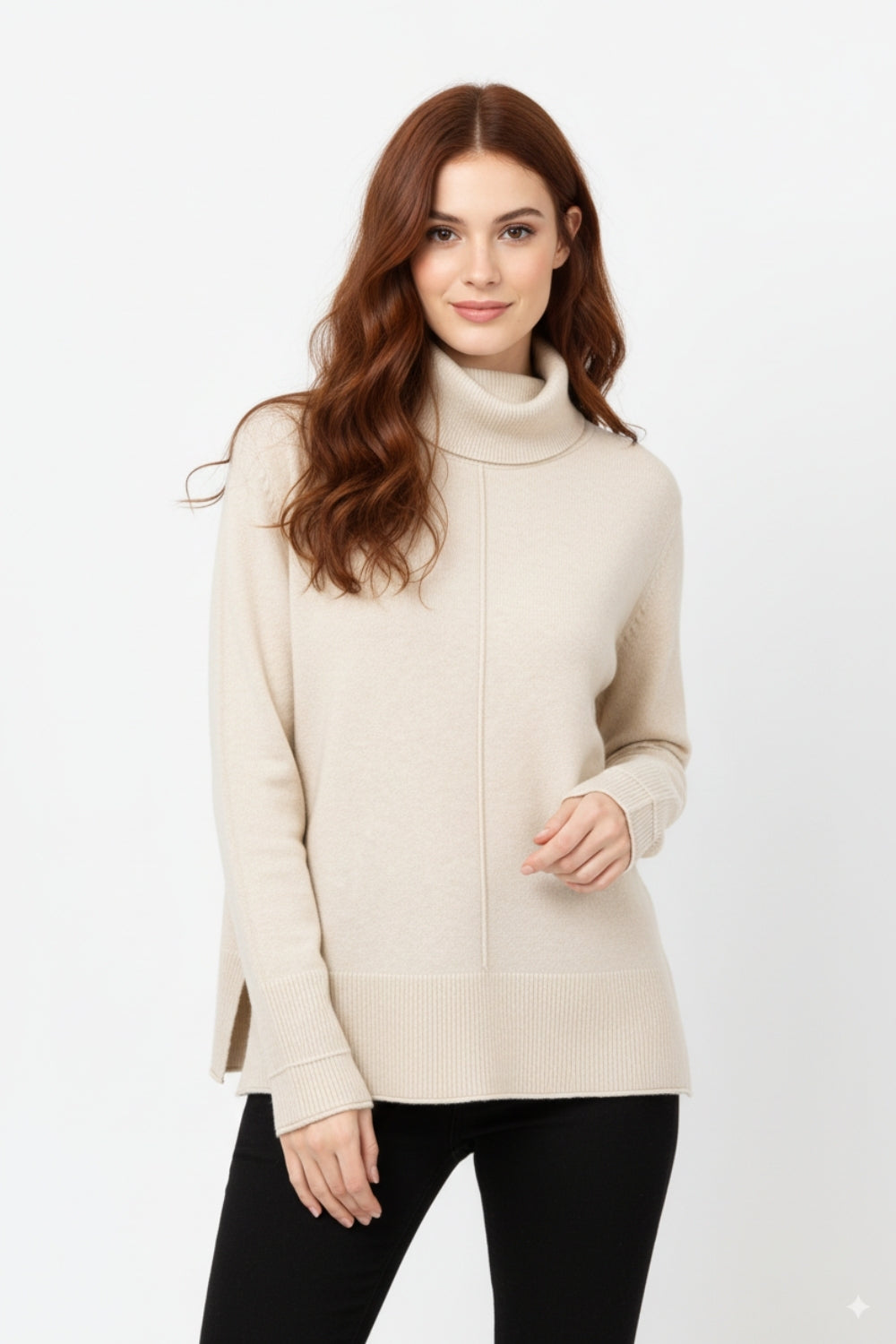 Modelo con jersey oversize de punto suave y cuello vuelto en color beige, combinado con pantalones negros.