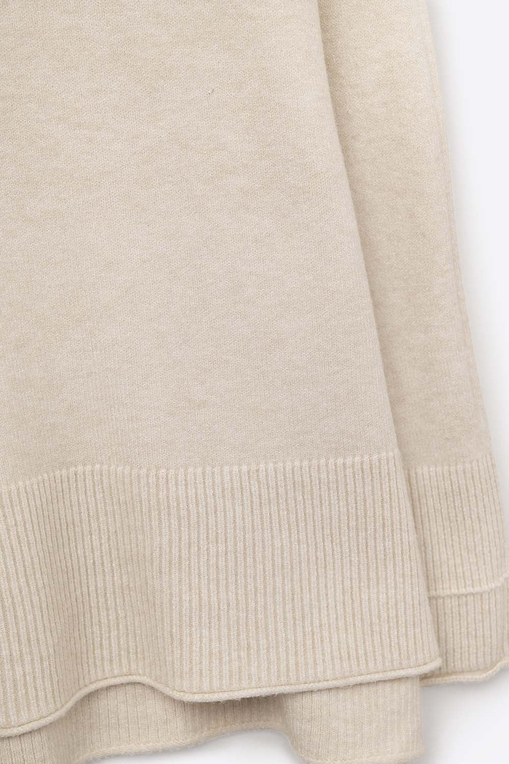 Primer plano del tejido de punto fino de viscosa de un jersey en color beige.