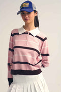 Mujer con gorra vistiendo jersey polo rosa de rayas con cuello blanco y falda blanca, estilo preppy.