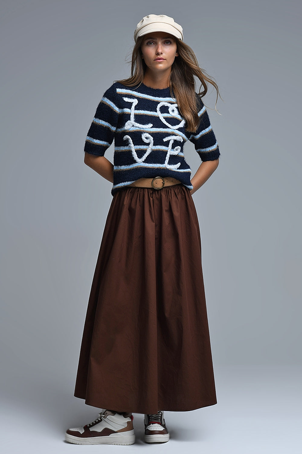 Look completo de mujer con jersey LOVE de manga corta, falda larga marrón y zapatillas deportivas.