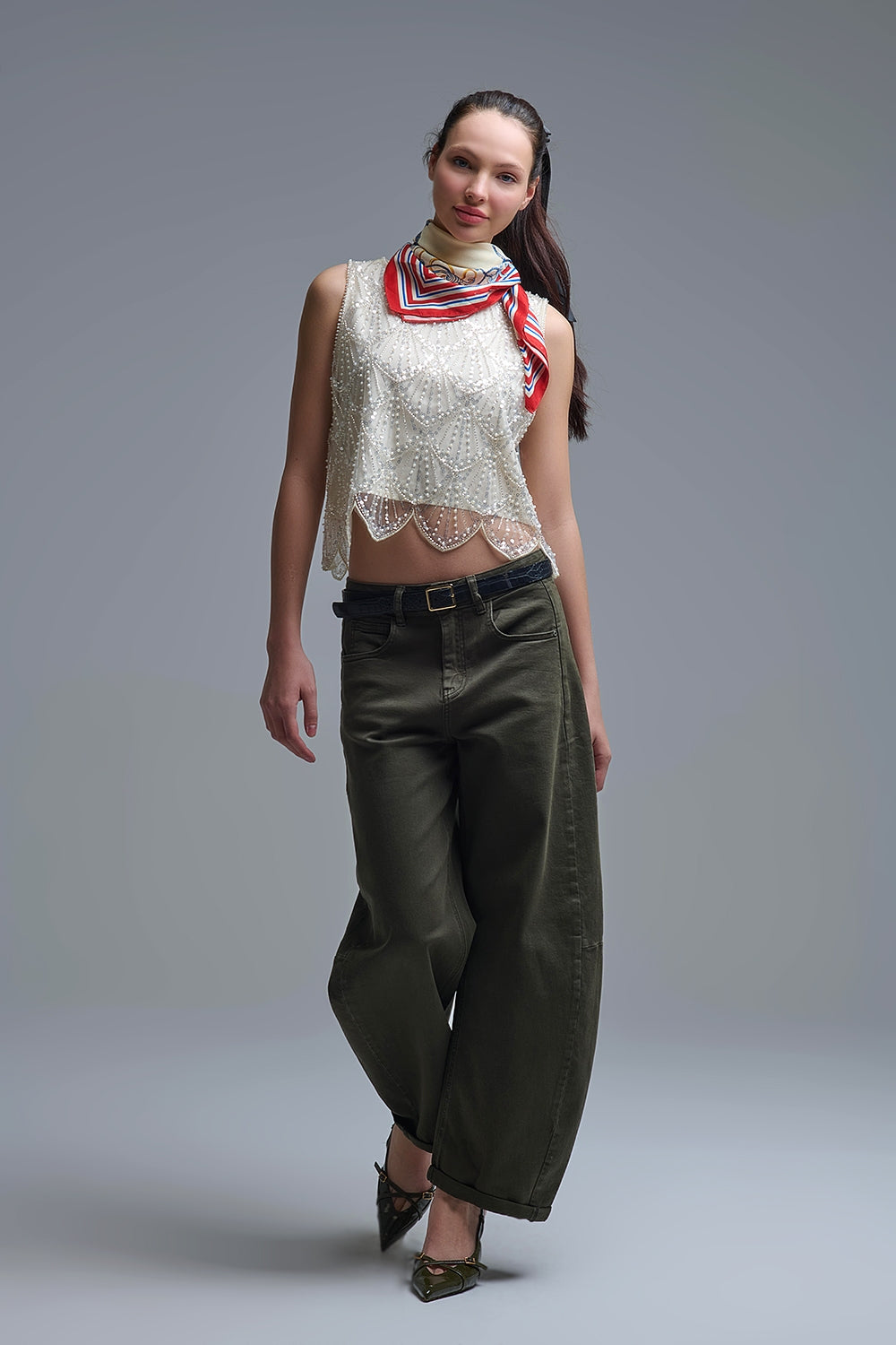 Look estilo urbano glam con top blanco joya y pantalones vaqueros.