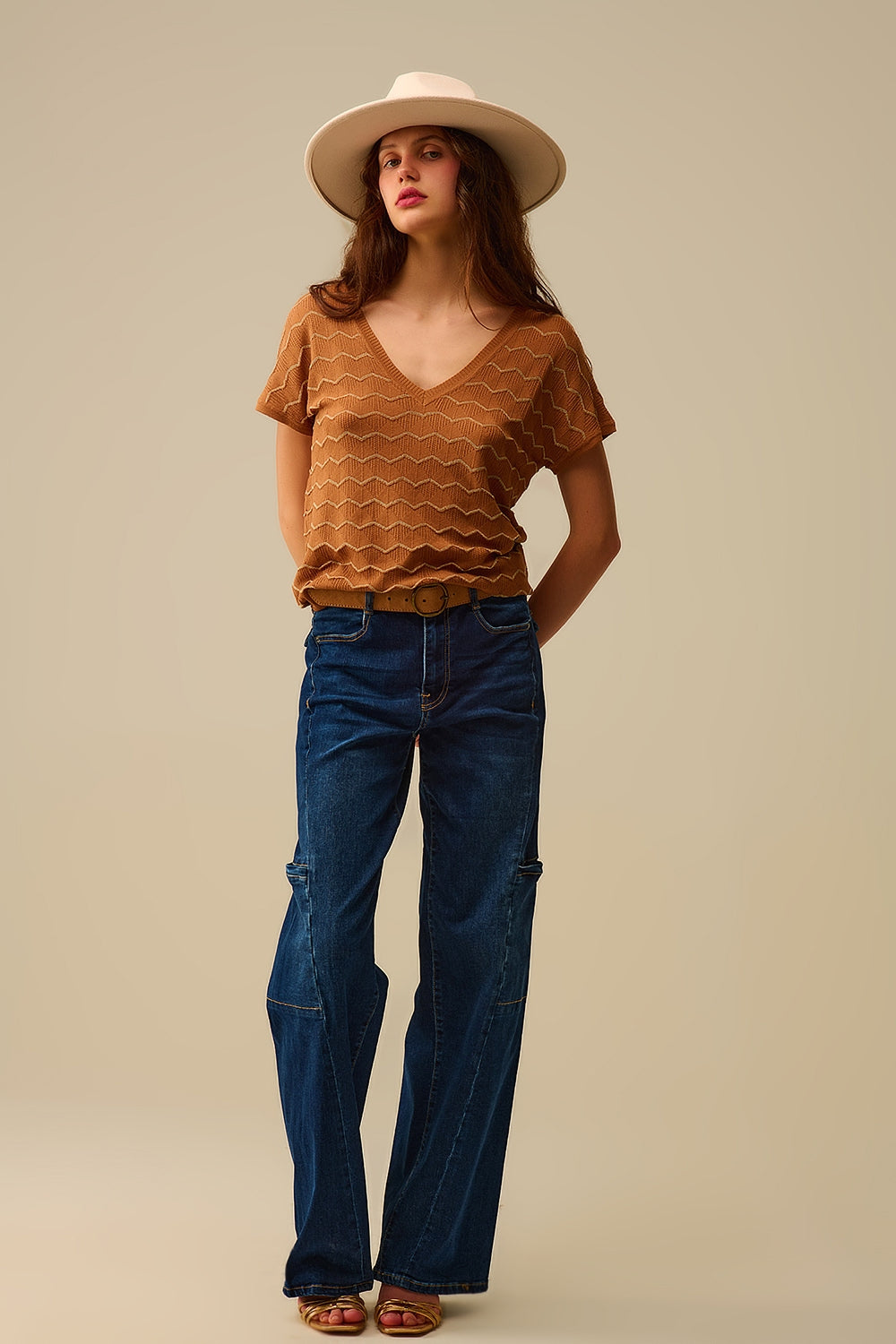 Modelo con look completo de vaquero cargo ancho de estilo utility y top de punto marrón.