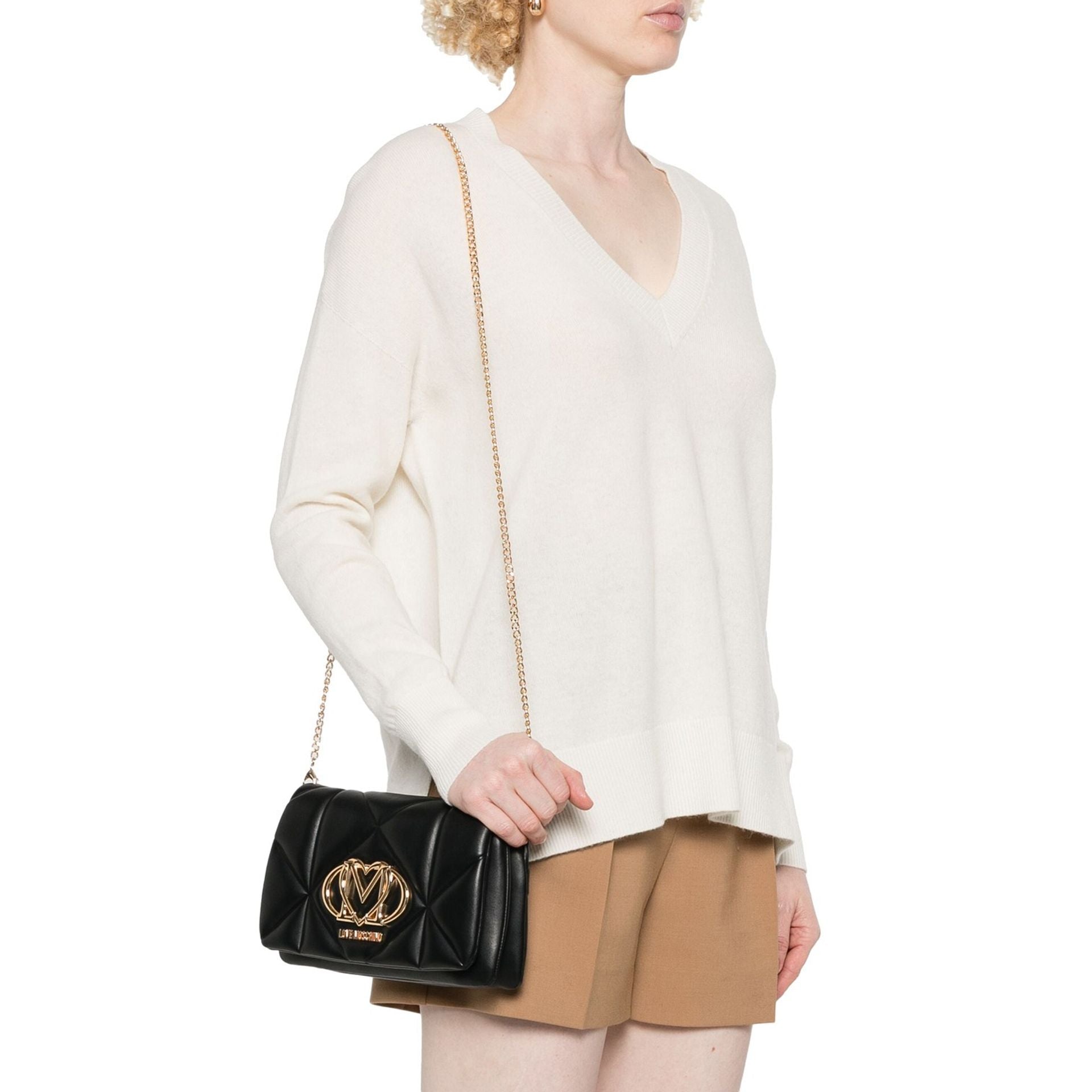 Mujer luciendo bolso bandolera negro Love Moschino al hombro.