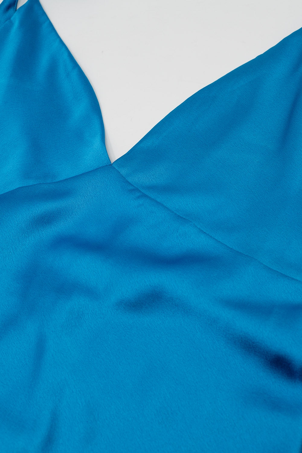 Primer plano del escote en V del vestido azul satinado