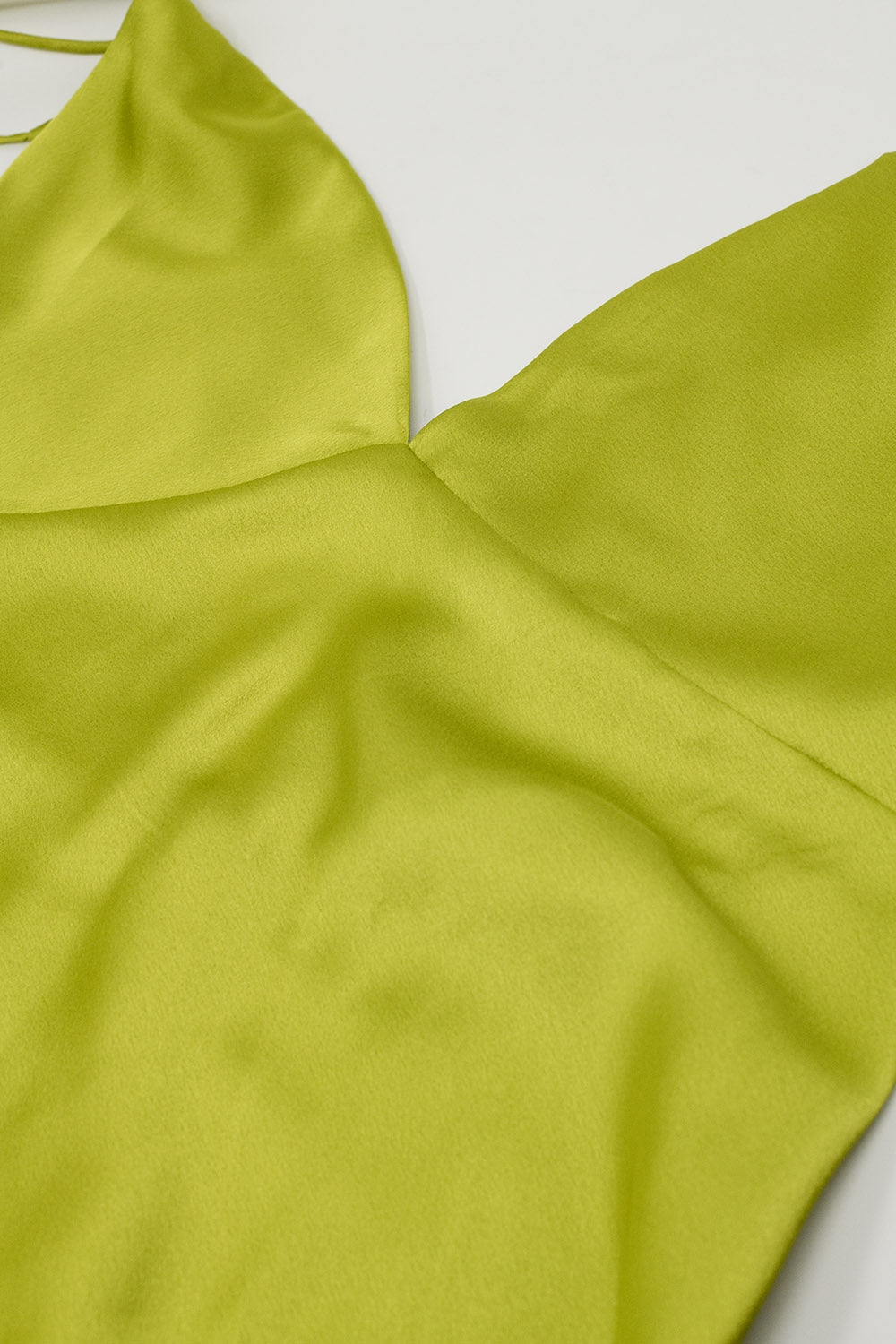Primer plano del escote en V del vestido verde lima satinado