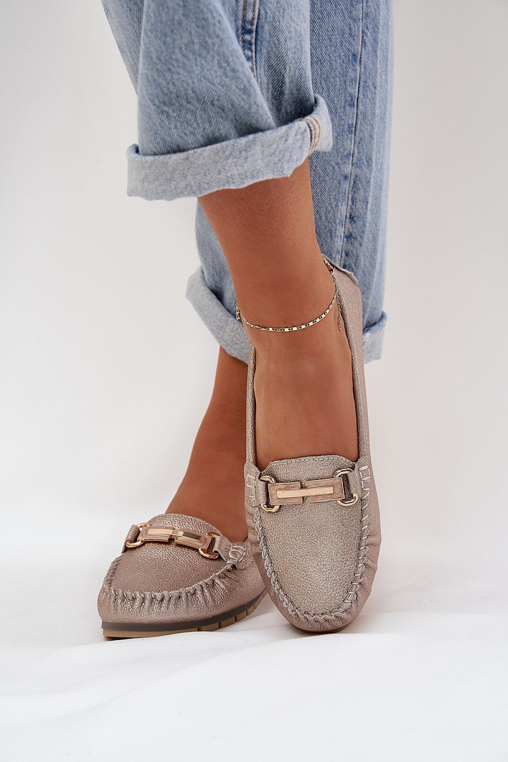 Mocasines dorados de mujer con detalle metalico y diseño en cuero natural, perfectos para el día a día.