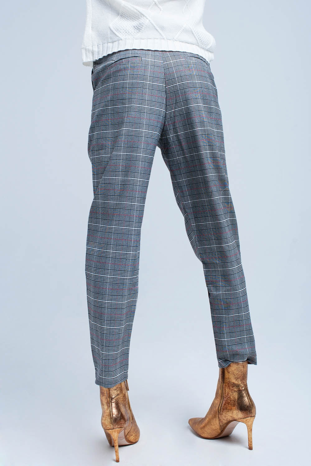 Vista trasera de un pantalón de sastre con estampado de cuadros en tonos grises.