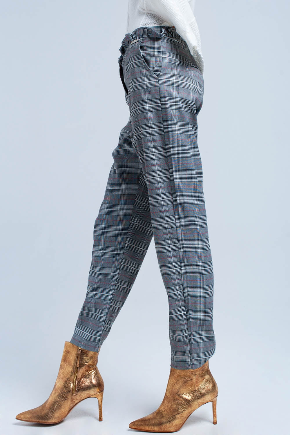 Vista de perfil de un pantalón de cuadros Príncipe de Gales de largo tobillero.