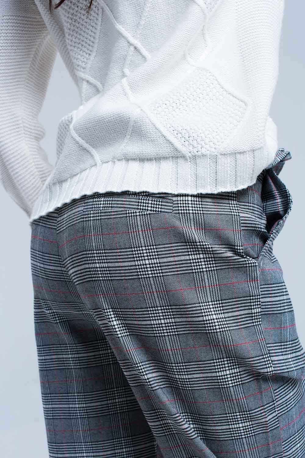 Vista trasera de un pantalón de sastre con estampado de cuadros en tonos grises.