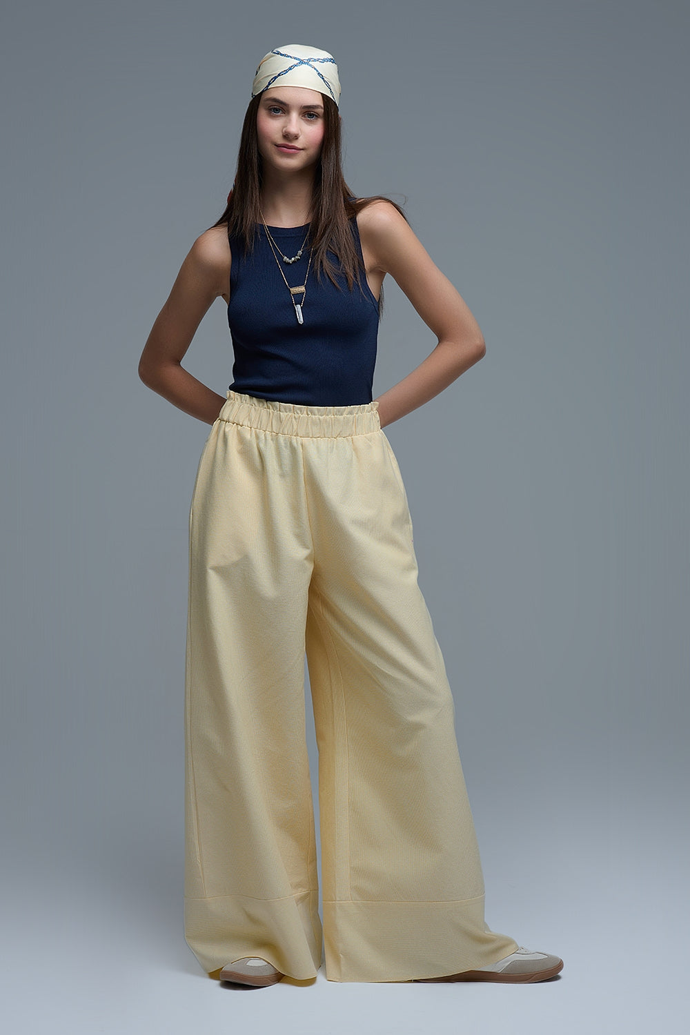 Pantalón ancho de mujer en color amarillo claro con rayas finas, talle alto elástico y bolsillos.